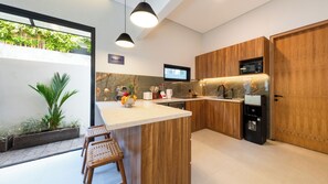 Eine moderne Küche mit Holzschränken, einer Marmorarbeitsplatte und einer eingebauten Mikrowelle.