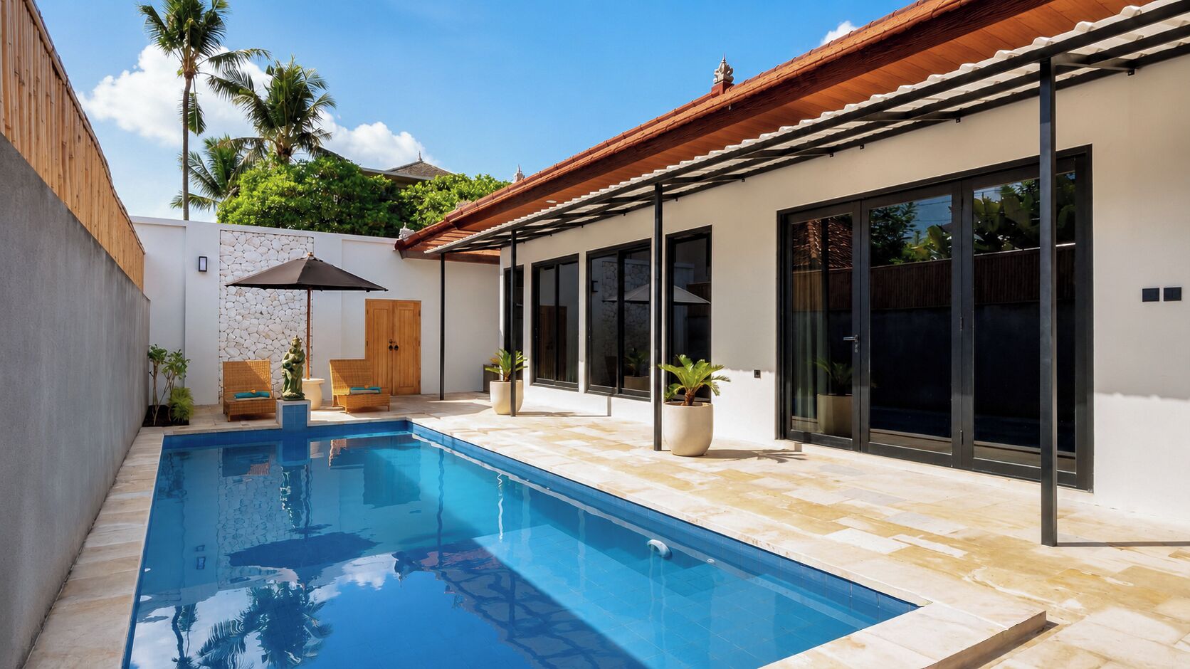 Une maison moderne dotée d’une piscine, d’une terrasse en bois et de grandes fenêtres.