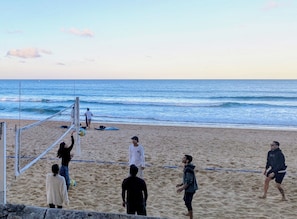 A beach volleyball game with players and a net on a sandy beach. - Apartment in Manly, Walk to beach (Manly)