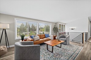 A modern living room with a sofa, armchairs, a coffee table, and a large window with blinds. - Modern Family Retreat Near Sea-tac, Marina & Seattle (Des Moines)