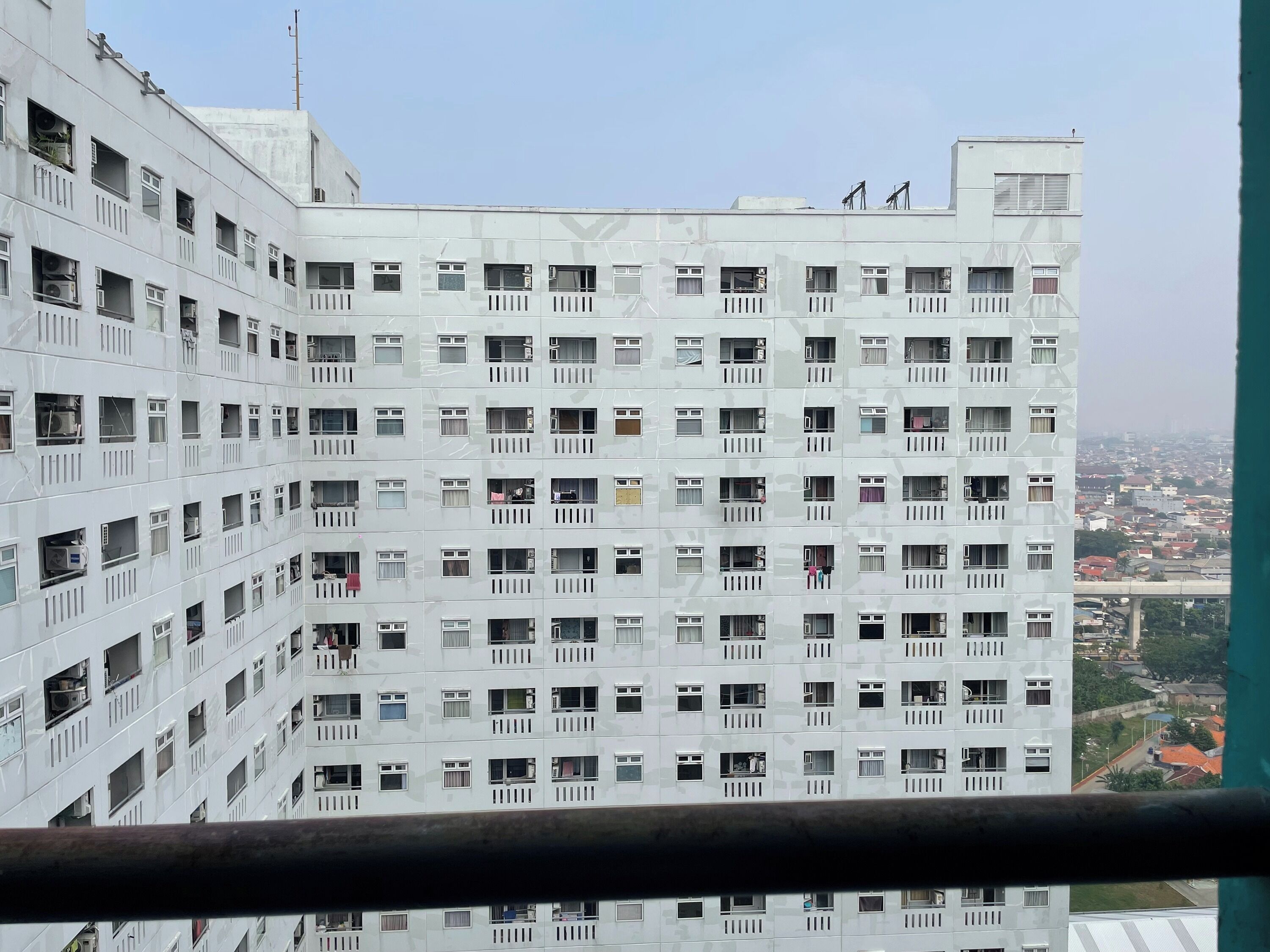 Un edificio alto con múltiples balcones y ventanas, visto desde un balcón.