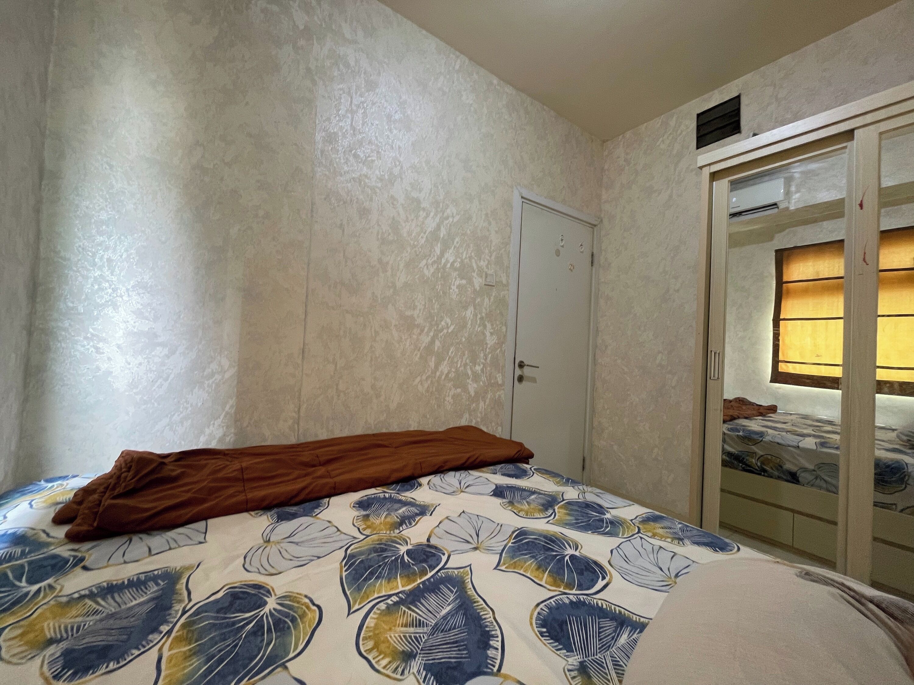 Une chambre à coucher avec un lit, une armoire et une fenêtre avec des rideaux.