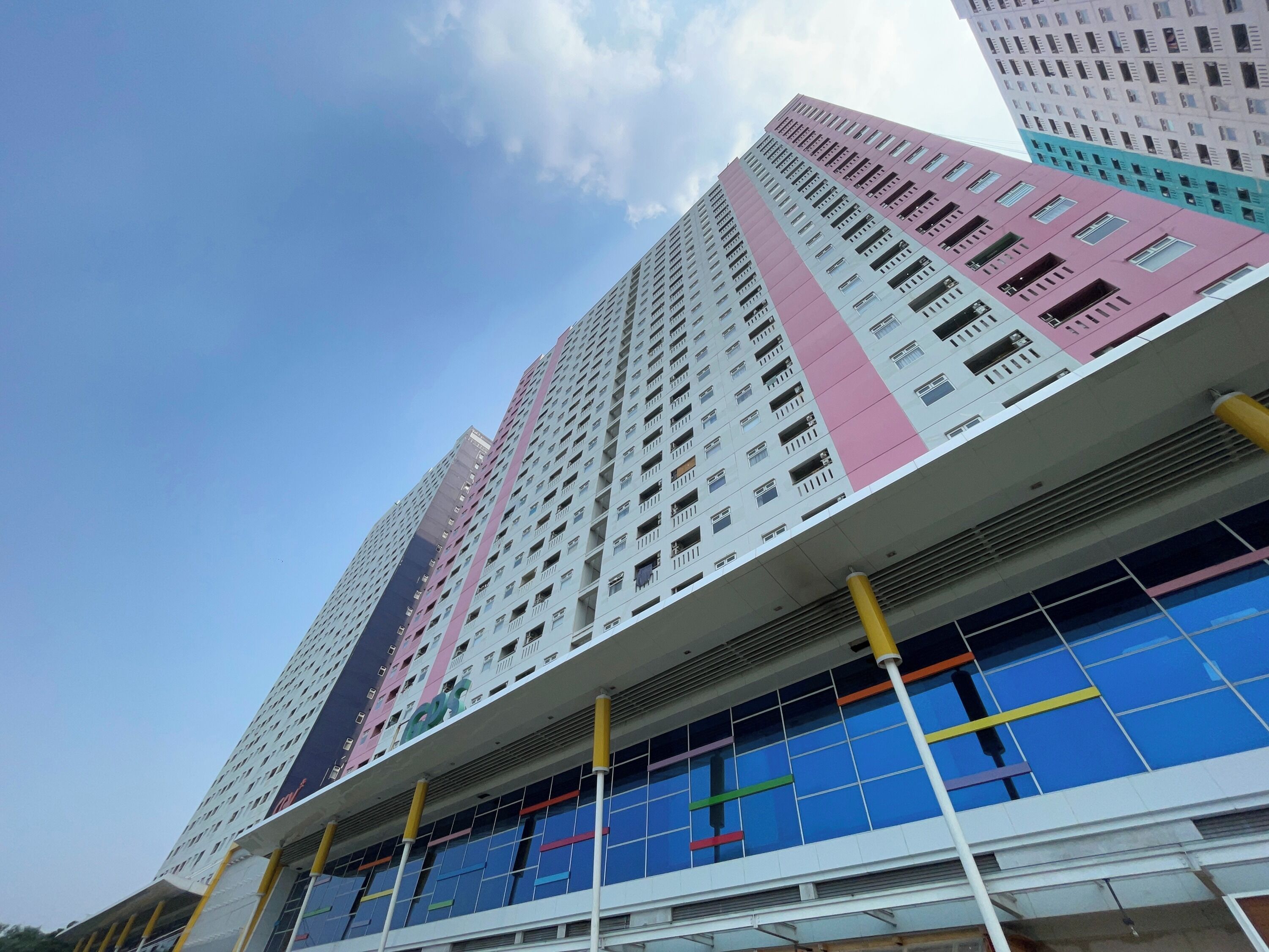 Un edificio de varios pisos con un diseño arquitectónico moderno, que presenta un llamativo patrón de líneas verticales en la fachada.