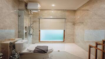 Un baño moderno con cabina de ducha de vidrio, inodoro y bidé.
