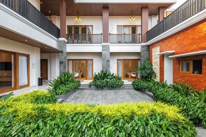 Un edificio moderno de varios niveles con un patio central, balcones y fachada de ladrillo.