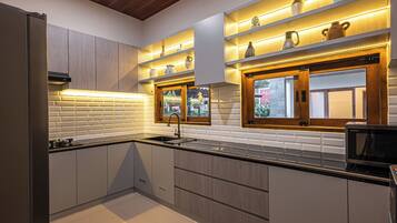 A modern kitchen with built-in appliances, a window with a view, and decorative shelves.