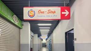 A corridor with a sign indicating the direction to the One-Stop Residence Hotel & Office. - Tikiibunk Packers (Kuala Lumpur)