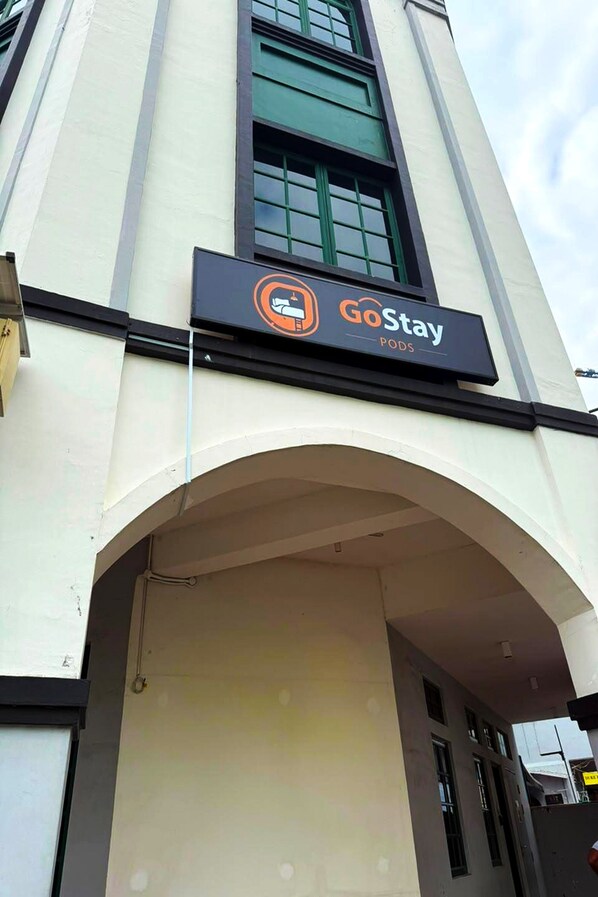 Un edificio con un cartel que dice 'GoStay PODS', indicando un hotel tipo cápsulas.