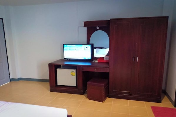 A bedroom with a bed, a desk with a computer, a mirror, and a wardrobe. - House Number 3 (Phitsanulok)