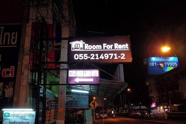 A building with a sign for a room for rent, a directional arrow sign, and a digital display with numbers. - House Number 3 (Phitsanulok)