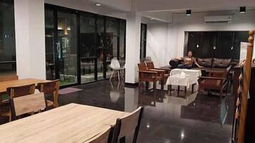 A modern interior with a dining area, seating, and a large window.