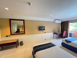 Een hotelkamer met een bed, een bureau, een stoel, een televisie en een raam.