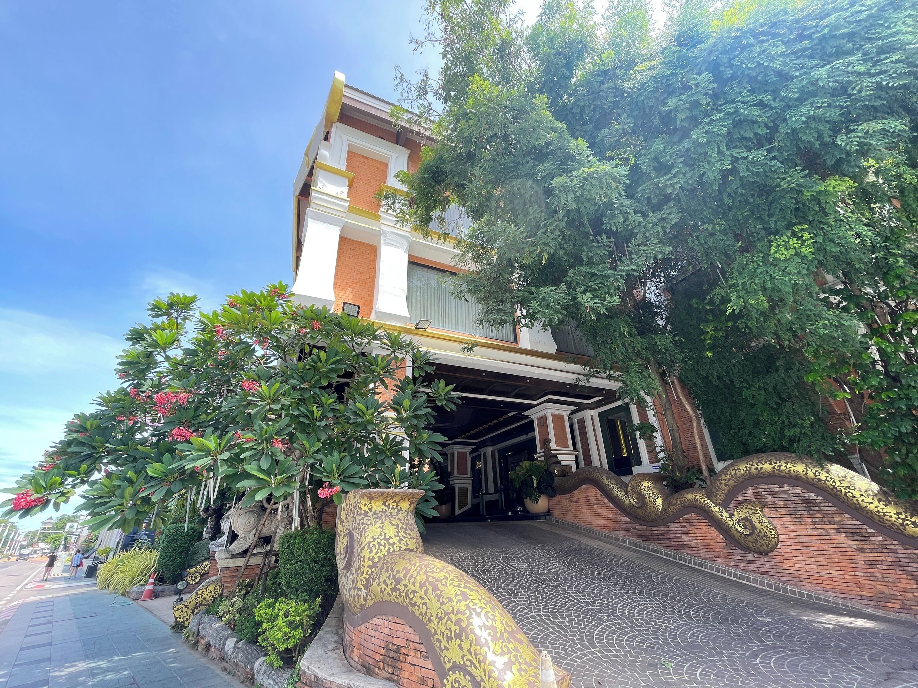Un edificio con vestíbulo cubierto, fachada de ladrillo y una escalera decorativa.