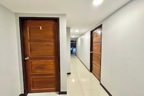 A corridor with wooden doors, numbered 1 and 2, leading to rooms. - Baan At Khaosan Hostel (Bangkok)