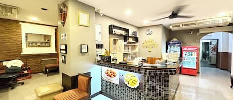 A hotel lobby with a reception desk, seating area, and a vending machine.