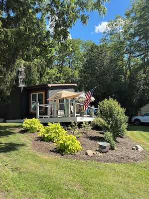 A house with a porch, a flag, and a garden.