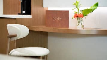 En receptionsdisk med et NALA-skilt, et kamera og en vase med blomster.