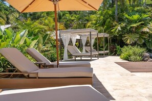 A poolside area with lounge chairs and a canopy. - NALA Resort (Mission Beach)
