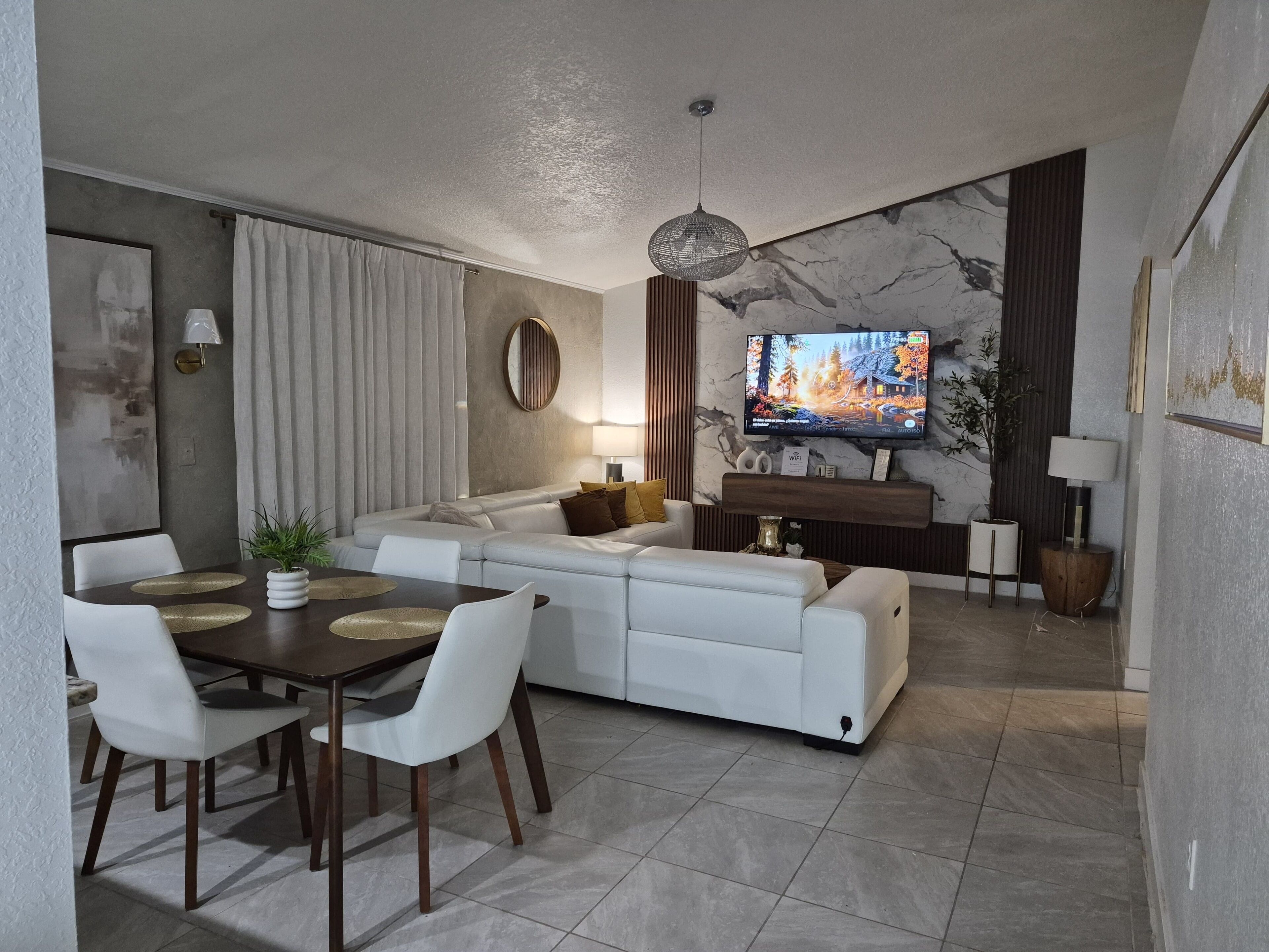 A modern living room with a sofa, dining table, and TV.