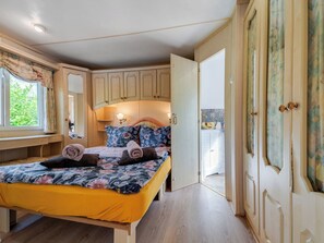 A bedroom with a bed, a desk, and a wardrobe. - Superior by Interhome (Leśna)