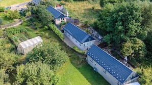 A residential area with multiple houses, a greenhouse, and a fenced field. - Superior by Interhome (Leśna)