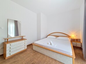 A bedroom with a bed, bedside tables, a dresser, and a mirror. - Vukelja by Interhome (Marina)