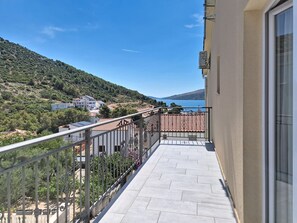 A balcony with a view of a hillside and a body of water. - Vukelja by Interhome (Marina)