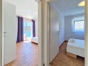 A room with a bed, a window, and a view of a balcony with curtains. - Vukelja by Interhome (Marina)