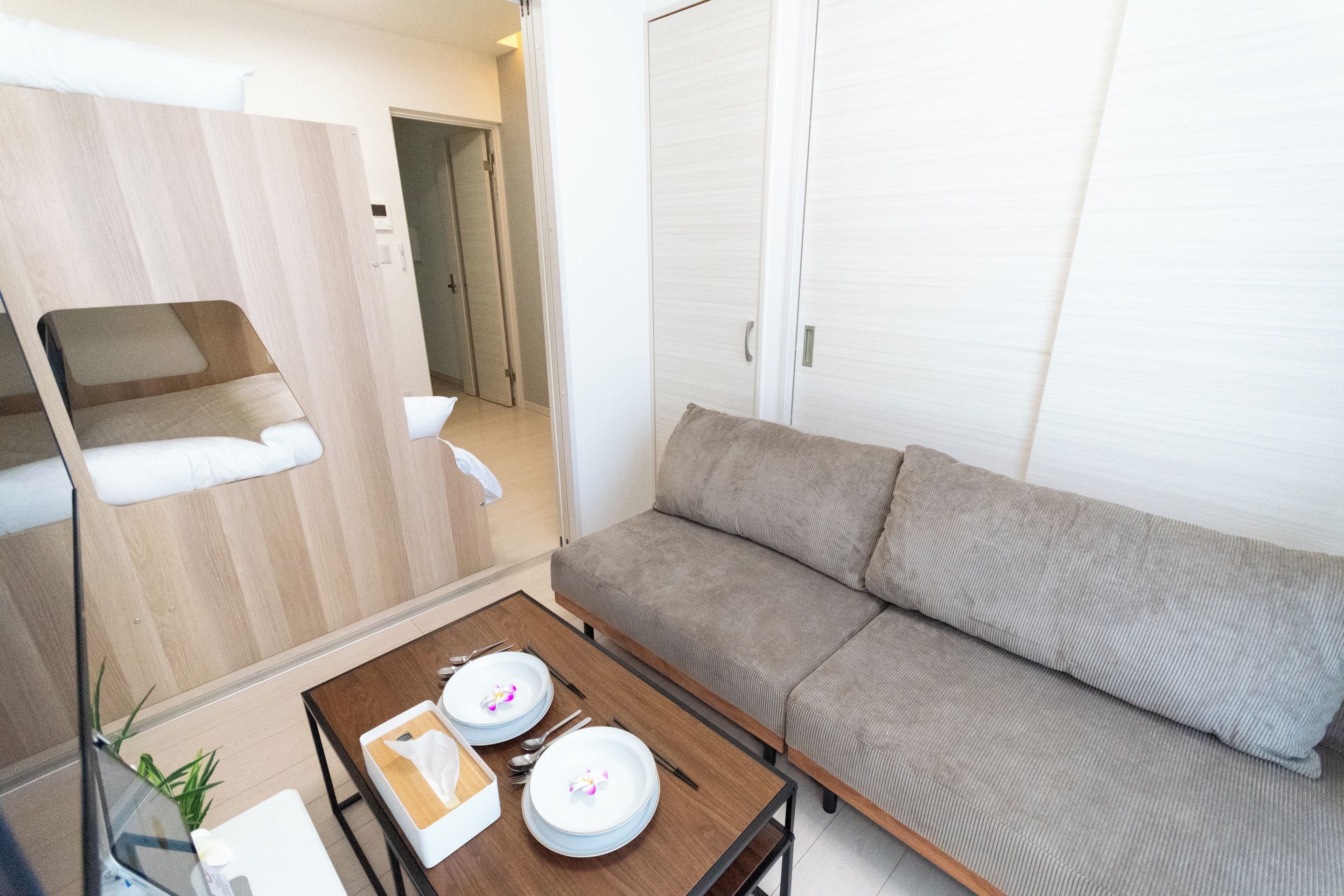 A compact living space with a sofa, a small dining table, and a kitchenette area.