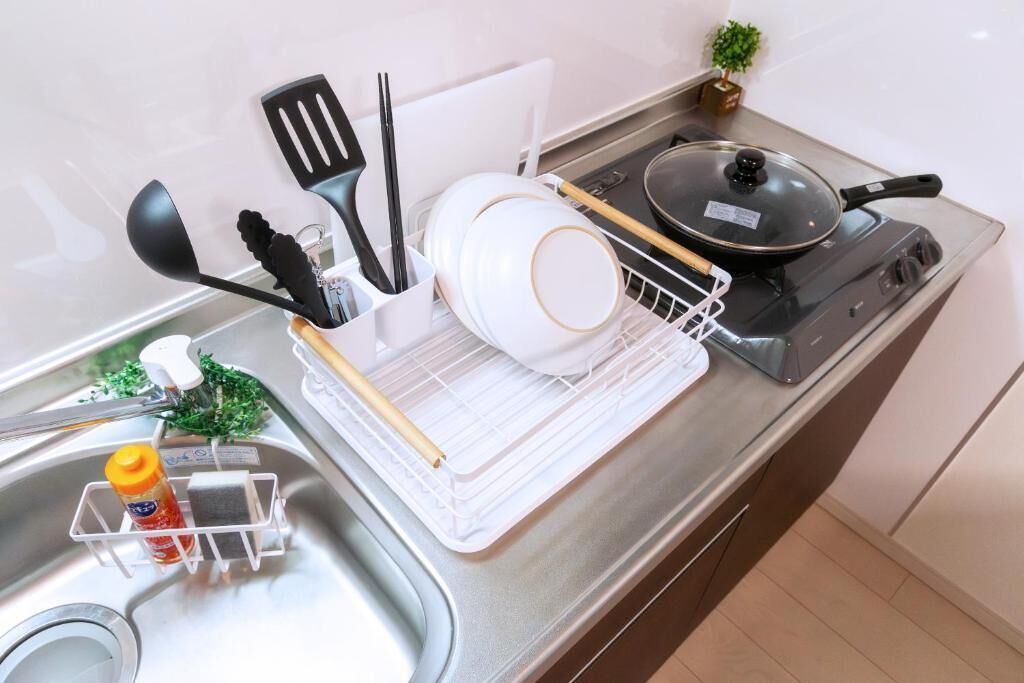 A kitchen with a stove, sink, and various utensils.