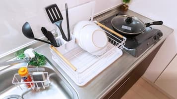A kitchen with a stove, sink, and various utensils.