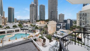 A high-rise hotel with a rooftop pool, multiple balconies, and a view of surrounding high-rise buildings. - Cozy 2 Double-bed Hotel Room | Max 4 guests (Surfers Paradise)