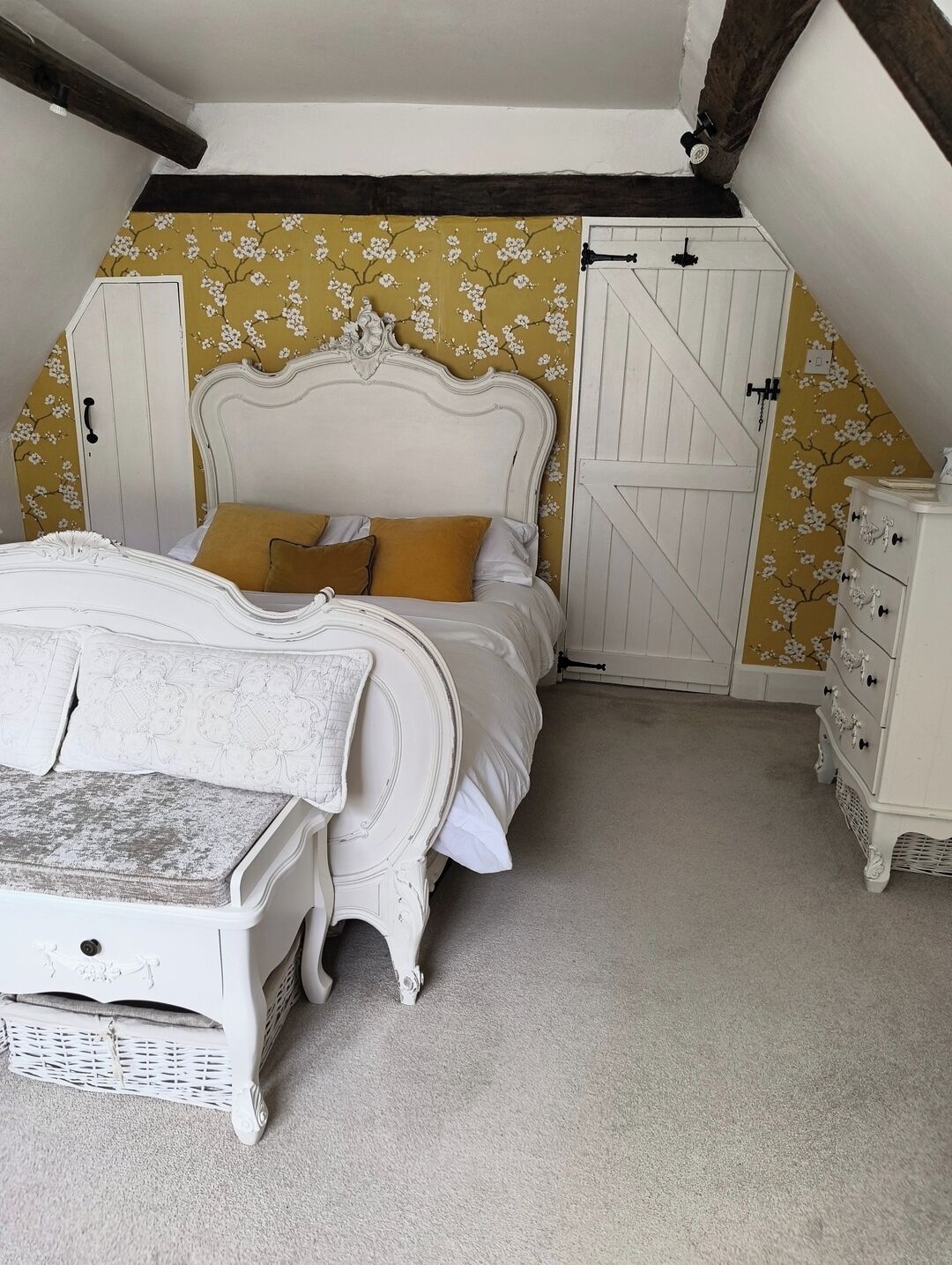 A bedroom with a bed, dresser, and wardrobe.
