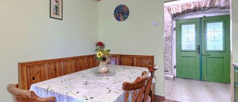 Un coin repas avec une table dressée pour six personnes, entourée de chaises en bois.