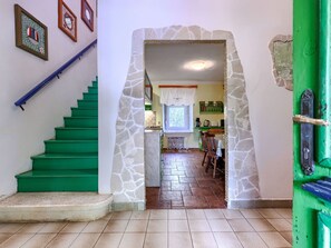 A staircase leading to a kitchen area with a stone archway. - Vacation home Helena by Interhome (Pula)