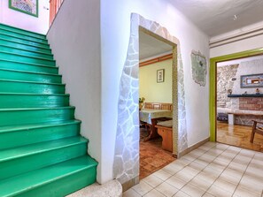 A staircase with green steps leading to a room with a stone wall and a tiled floor. - Vacation home Helena by Interhome (Pula)