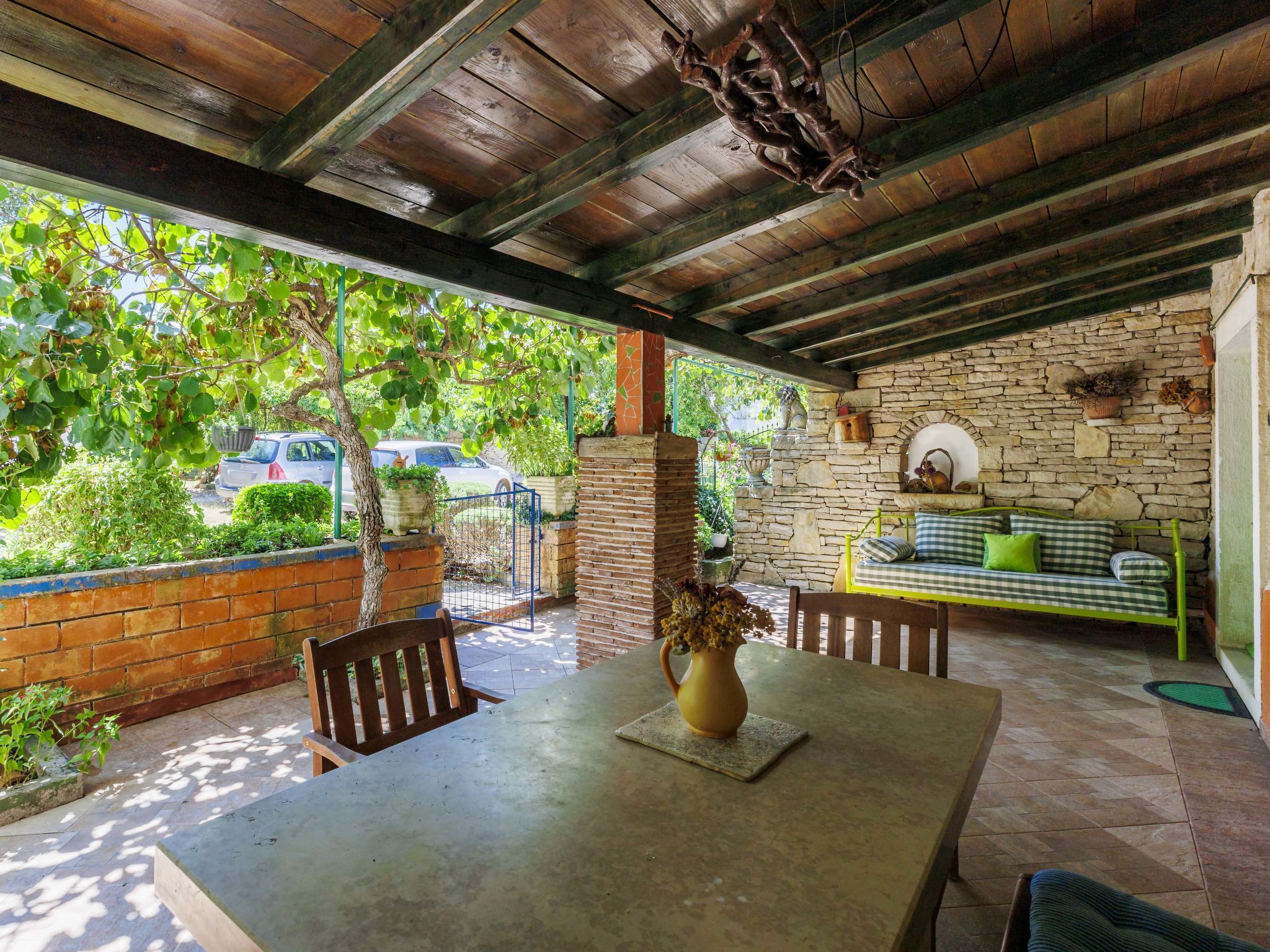Eine Terrasse im Freien mit Tisch, Stühlen und einer Steinmauer.
