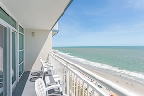 A balcony with a view of a beach and ocean. - 2BR Oceanfront View at Carolinian with Amazing  Pool (Myrtle Beach)