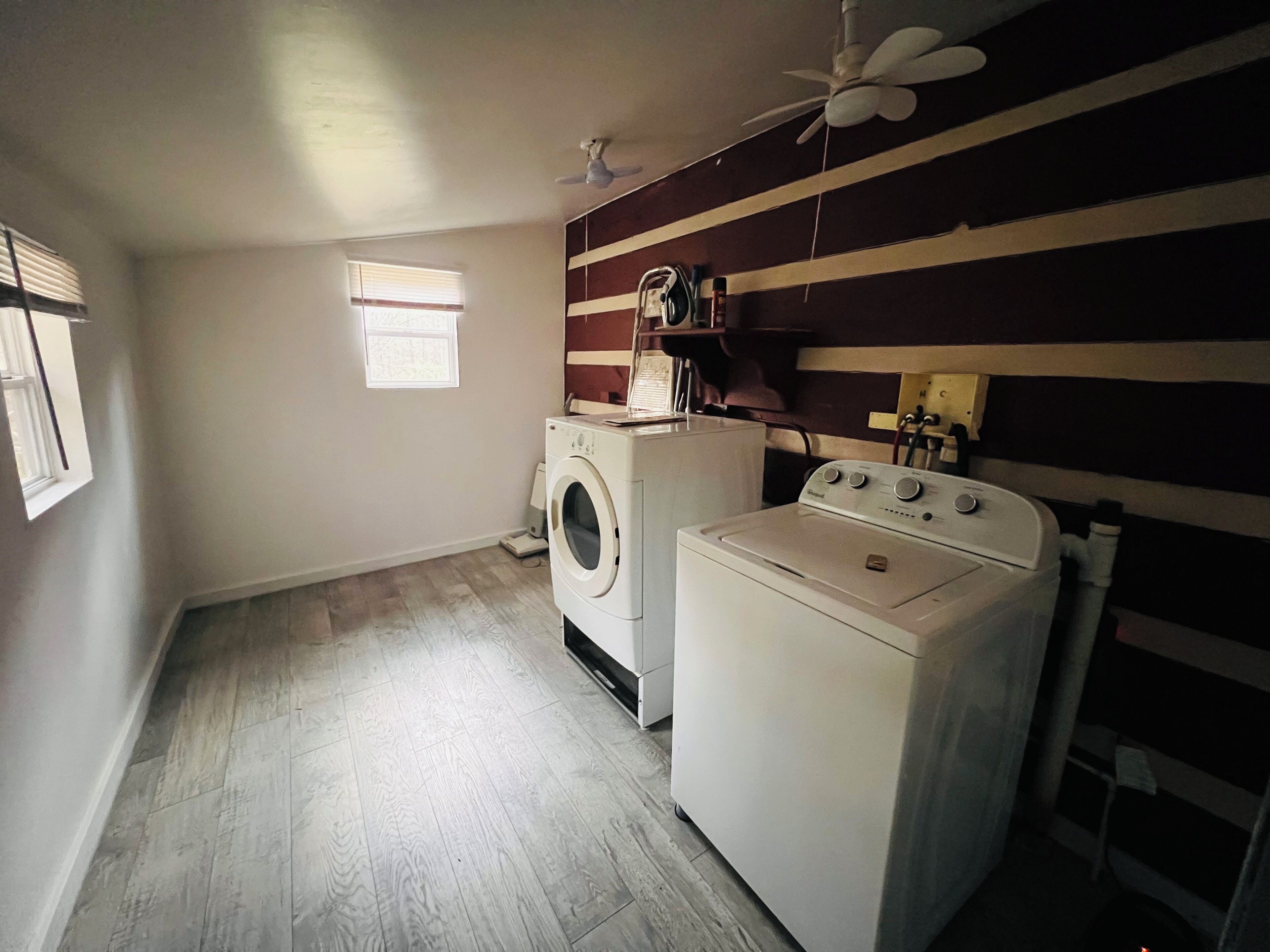 A laundry room with a washing machine, dryer, and ceiling fan.