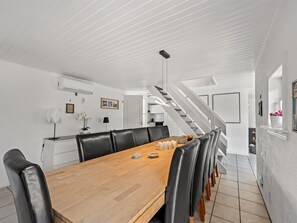 A modern dining area with a wooden table, black leather chairs, and a staircase leading to an upper level. - "Eufemia" - 2.8km from the sea by Interhome (Blåvand)