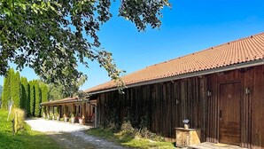 A rustic barn-style building with a gravel driveway leading to a wooden porch. - Edelweiss Suite 9 by Interhome (Kaprun)