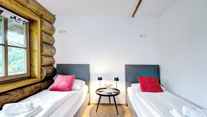 Ein Zimmer mit zwei Betten, einem kleinen Tisch mit einer Lampe und einem Fenster mit Blick.
