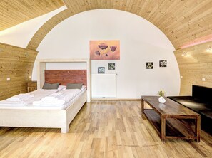 A bedroom with a wooden ceiling, a bed, a bedside table, a radiator, and a painting on the wall. - Sweet Edelweiss 5a by Interhome (Kaprun)