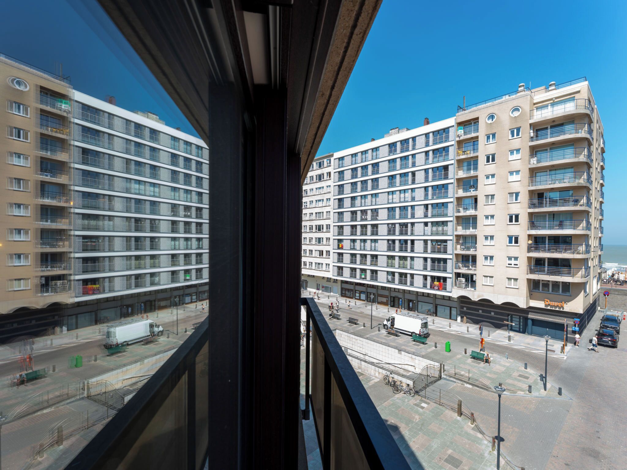 A high-rise building with multiple balconies and a clear view of the street below.