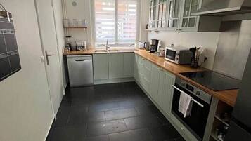 A compact kitchen with a dishwasher, microwave, and oven.