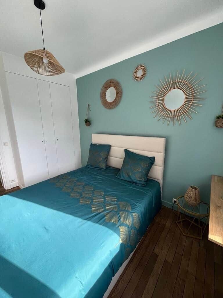 A bedroom with a bed, a wardrobe, and wall decorations.