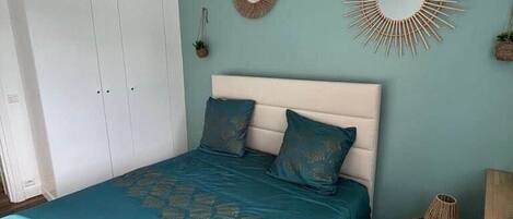 Een slaapkamer met een bed, een kledingkast en decoratie aan de muur.