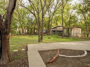 A backyard with a paved area, a brick pathway, and a small shed. - Lux Modern 3BR • King Bed • SmartTV • MassageChair • Pet Friendly • Near Ft Hood (Killeen)