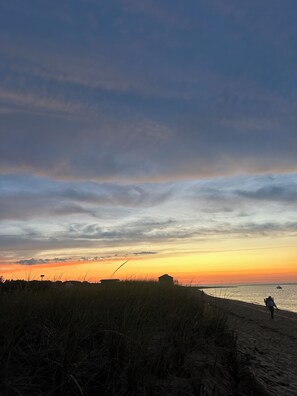 A beach with a sunset, grassy dunes, and a distant boat. - Amazing 4-bedroom house with beautiful views in gorgeous Aquinnah (Aquinnah)