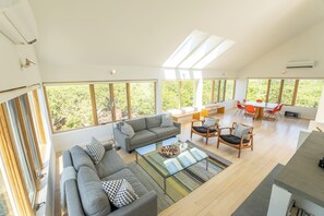 Ein geräumiger Wohnbereich mit einer großen Couch, einem Couchtisch und einem Esstisch mit Stühlen.